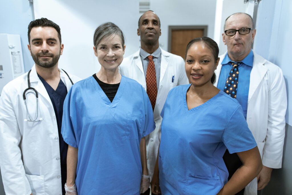 Group of diverse healthcare professionals posing confidently indoors.